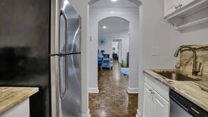 Una cocina con un refrigerador de acero inoxidable, una encimera de madera y un fregadero con salpicadero de mármol.