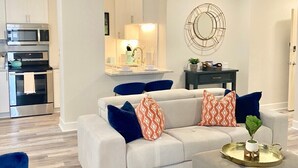 A modern living room with a sofa, coffee table, and a ceiling fan. - FIFA 2026 Walk to Stadium | 1BR Unit 8K ATL (Atlanta)