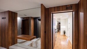 Interno moderno di un hotel con pannelli in legno, una scala e una targa con il numero '407'.