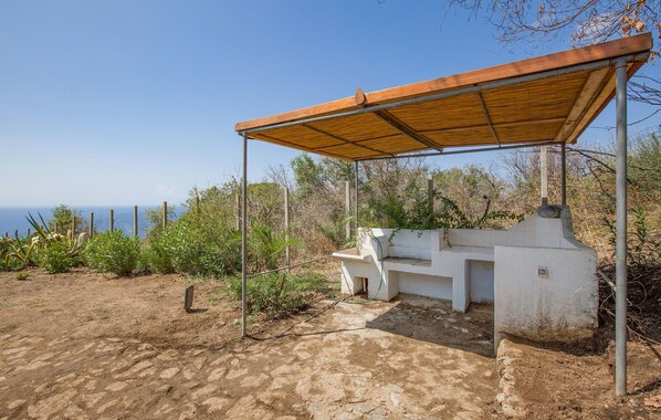 Un área de estar al aire libre con techo y vistas al océano.