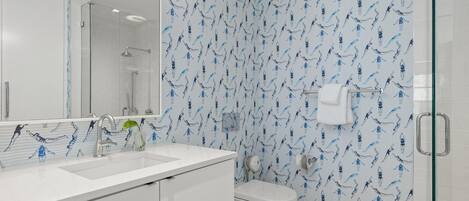 Une salle de bain moderne avec un lavabo blanc, une douche en verre et des toilettes.