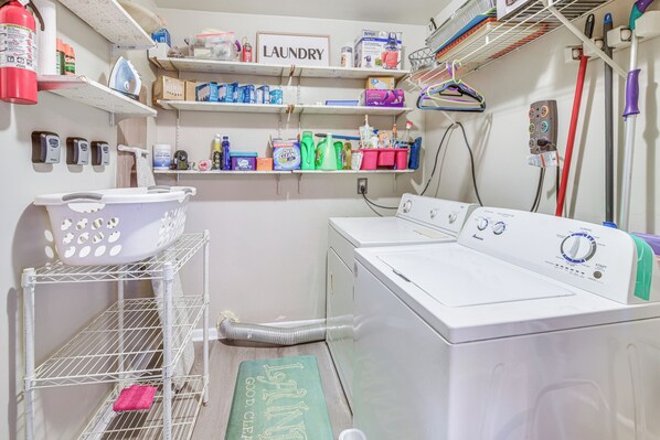 A laundry room with a washing machine, shelves with laundry supplies, and a fire extinguisher. - Colonial Heights Home w/ Large Yard & BBQ Grill! (Colonial Heights)