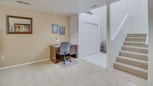 Ein Arbeitszimmer mit Schreibtisch, Stuhl und einem großen Spiegel an der Wand.