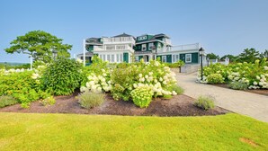 Ein großes, mehrgeschossiges Haus mit gepflegtem Garten und einem gepflasterten Weg zum Eingang.