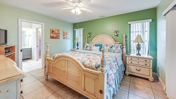 A bedroom with a wooden bed, a nightstand, a dresser, and a ceiling fan. - Marco Island Home w/ Private Pool & Water Views! (Marco Island)