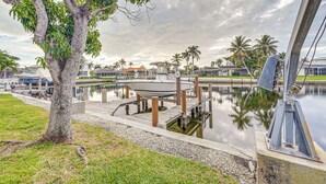 A marina with docked boats, a tree, and a clear sky. - Marco Island Home w/ Private Pool & Water Views! (Marco Island)