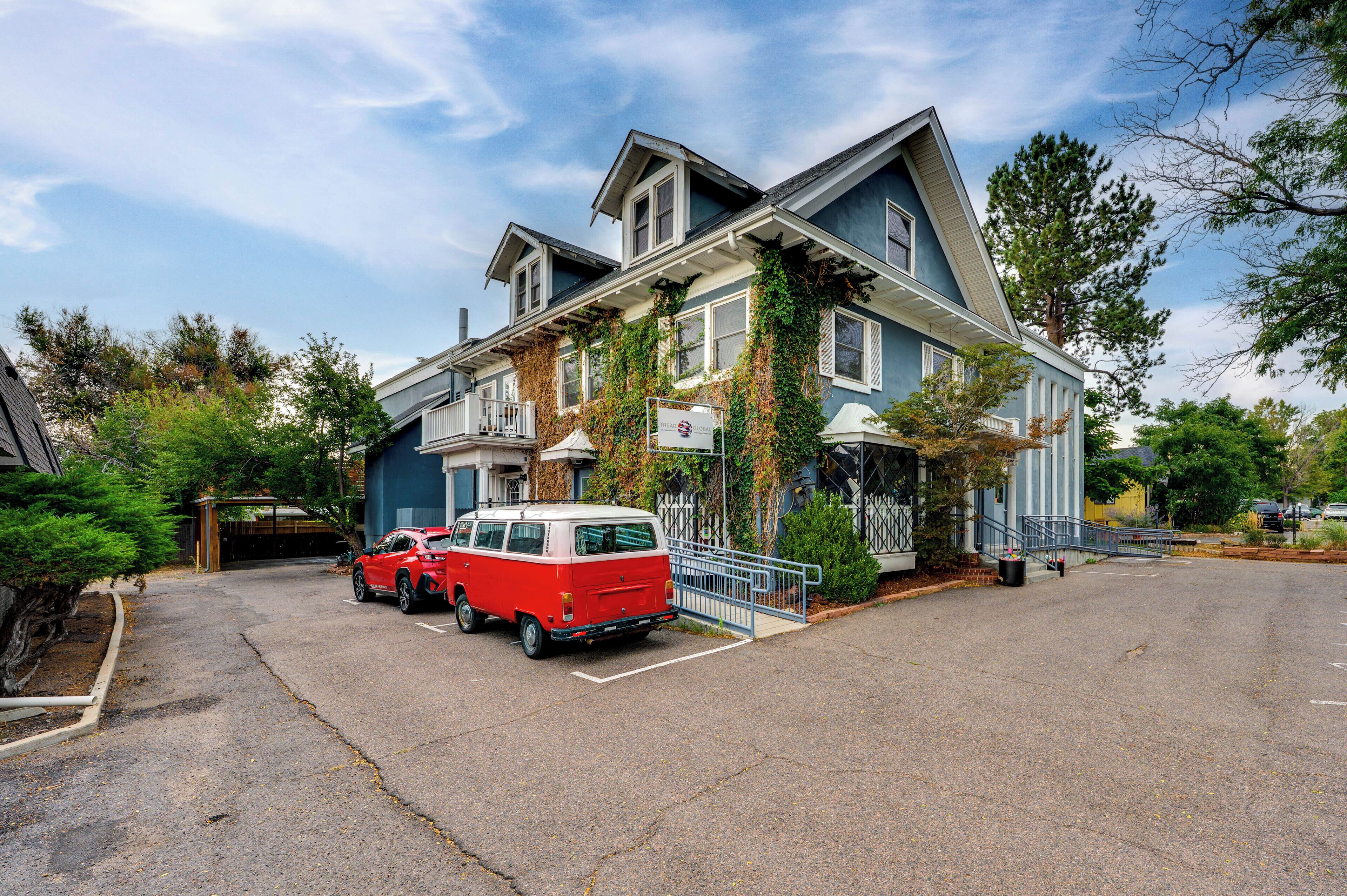 A two-story house with a garage and a red and white van parked in front.
