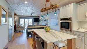 A modern kitchen with a marble island, wooden ceiling, and stainless steel appliances. - Lakefront Townhome w/ Dock: 6 Mi to Blue Ridge! (Morganton)