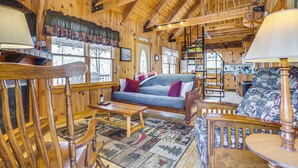 A wooden interior with a sofa, chairs, a table, and a patterned rug. - Quaint Dahlonega Cabin w/ Cavenders Creek Access! (Dahlonega)