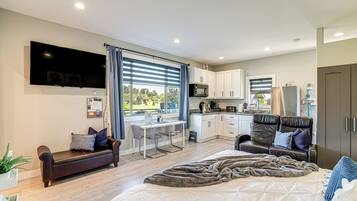Una sala de estar moderna con sofá, cama grande, comedor y cocina.