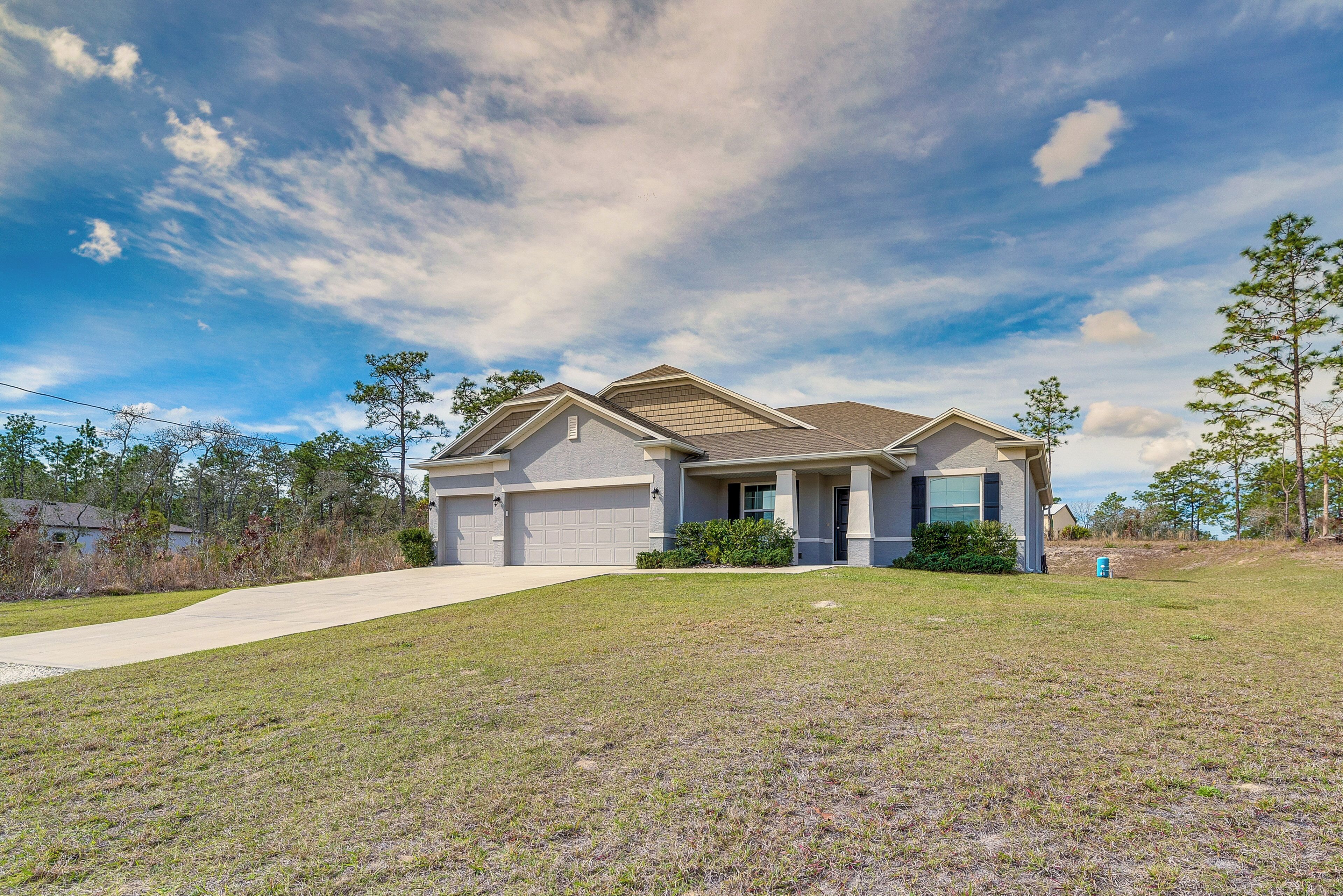 A single-story house with a front garage, a covered porch, and a well-maintained lawn.