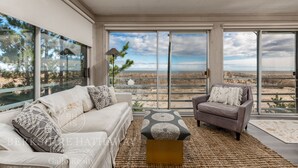 Una sala de estar moderna con un amplio ventanal que ofrece vistas a un paisaje desértico.