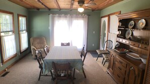 A dining room with a wooden table, chairs, and a ceiling fan.