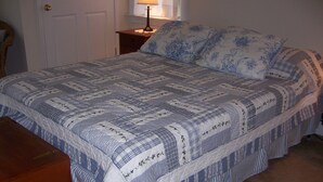 A neatly made bed with a blue and white patterned bedspread and matching pillows. - Just a block to the beach!  701 Cedar (Lewes)
