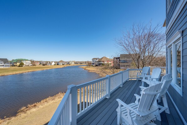 A waterfront property with a deck, chairs, and a view of a river. - Lots of living space in this large home in The Peninsula - 33478 Islander (Millsboro)