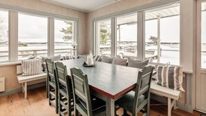 A dining area with a large table, multiple chairs, and a bench seating area. - Seaside Bliss for Families: Home Away from Home (Stockholms län)
