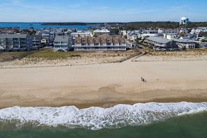 A coastal town with beachfront properties, a sandy beach, and a view of the ocean.