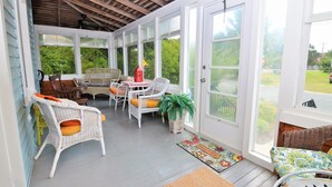 A covered porch with wicker furniture, a red lantern, and a welcome mat. - 8 Rhode Island - BAY BLOCK HOME, STEPS FROM LEWES BEACH (Lewes)