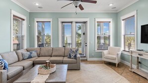 A living room with a sectional sofa, a coffee table, and a ceiling fan. - Lazy Beach, Spacious + Shared Pool & 5-Min Walk to the Sand! (Panama City Beach)