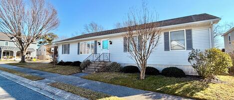 A single-story residential house with a front porch, a small front yard, and a driveway.