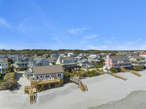 A coastal residential area with houses, sandy beach, and wooden walkways. - Mimis Cloud - Oceanfront, 4-bedrooms (Pawleys Island)