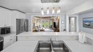 A modern kitchen with a large island, stainless steel appliances, and pendant lighting. - Peace of Pawleys - Creek Front, 3-bedroom (Pawleys Island)