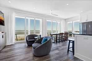 A modern kitchen with a large island, white cabinetry, and a stainless steel refrigerator. - RECENTLY BUILT 4 Bedroom, 4 1/2 bath home with Luggage Lift, Oceanfront (Edisto Island)