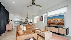 A modern living room with a large flat-screen TV, leather sofa, and a wooden coffee table. - US1211 | Modern Interiors | A/C | Roof Top Hot Tub (Steamboat Springs)