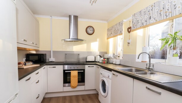 A compact kitchen with a microwave, oven, toaster, and sink.