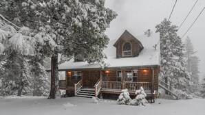 A log cabin with a steep roof, a front porch, and a visible address sign. - Log Cabin Hideaway- Cozy Mountain Getaway (Arnold)