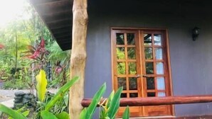 Une porte en bois avec des panneaux de verre, un mur en pierre et une rambarde en bois.