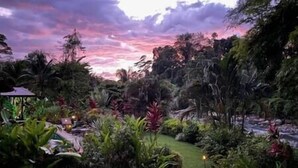 Un jardin luxuriant agrémenté d’un belvédère et d’un petit étang.