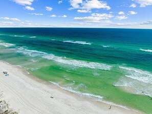 A beach with clear turquoise waters and a sandy shore.
