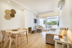 A modern living room with a dining area, a sofa, a TV, and a fireplace. - Balaia 3BR Sunny Terrace (Albufeira)