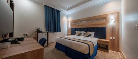 A hotel room with a bed, desk, and a small cabinet.