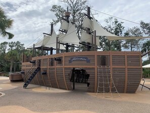 A pirate-themed play structure with a ship design, including a ladder and ropes.