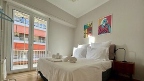 A bedroom with a bed, a nightstand, a lamp, and artwork on the wall. - Spacious 2 Bedrooms Apartment With Acropolis View In Center of Athens (Athina)