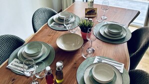 A dining table set with plates, glasses, and a bottle, with a view of the outside balcony. - Spacious 2 Bedrooms Apartment With Acropolis View In Center of Athens (Athina)