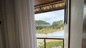 A balcony with a view of a beach and palm trees. - Guarapari Park (Guarapari)