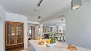 A modern kitchen with a marble countertop, a wooden cabinet with glass doors, and a bowl of fruit. - Comfortable Villa Ajda with sea view and heated pool (Pula)