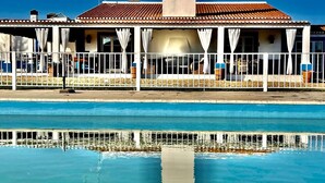 A poolside view of a building with a tiled roof and a large vertical structure.