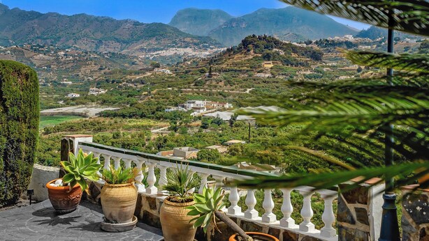 A balcony with potted plants overlooking a mountainous landscape with buildings. - Villa Los Sanchez - Two Bedroom Villa, Sleeps 4 (Frigiliana)