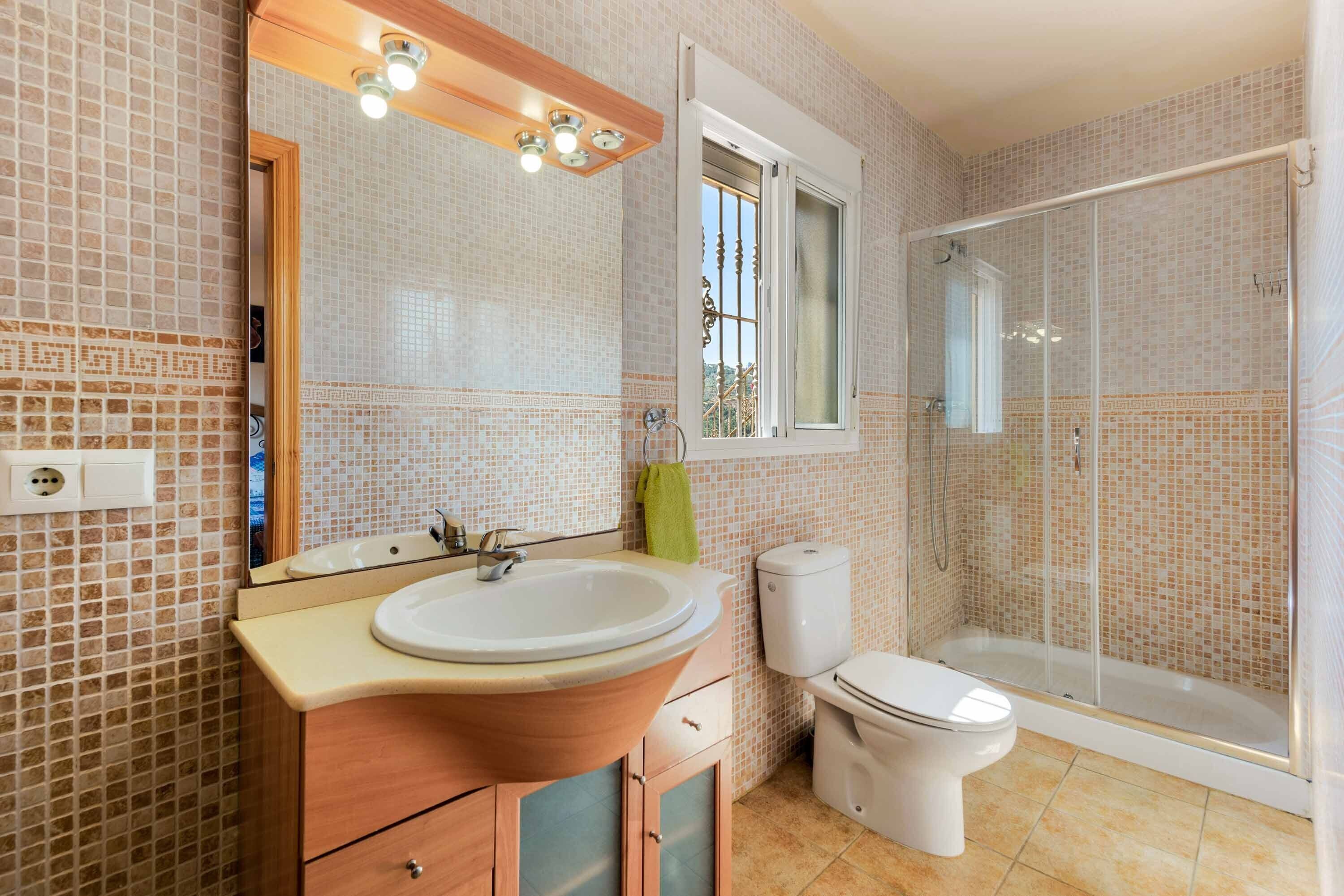 Een badkamer met een wastafel, toilet en douche.