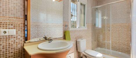 A bathroom with a sink, toilet, and shower.