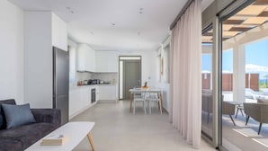 Een modern appartement met keuken, eethoek en een balkon met buitenmeubilair.