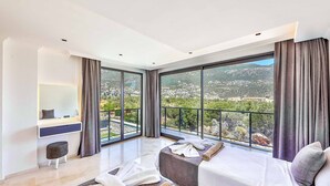 Une chambre d’hôtel moderne dotée d’un grand balcon, d’un bureau avec une chaise et de deux lits.