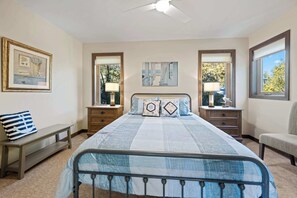 A bedroom with a bed, bedside tables, a bench, and a chair. - Waterfront! New Construction The Resting Place (Sturgeon Bay)