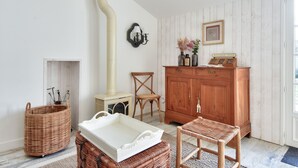 A room with a white wall, a wooden cabinet, a wicker chair, a wicker basket, and a white tray. - House for 6 in the heart of Bretignolles-sur-Mer (Bretignolles-sur-Mer)