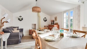A dining area with a table set for six, surrounded by wooden chairs. A woven light fixture hangs above the table. - House for 6 in the heart of Bretignolles-sur-Mer (Bretignolles-sur-Mer)