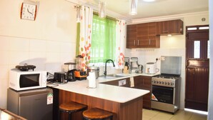 A compact kitchen with a microwave, toaster, sink, and stove.